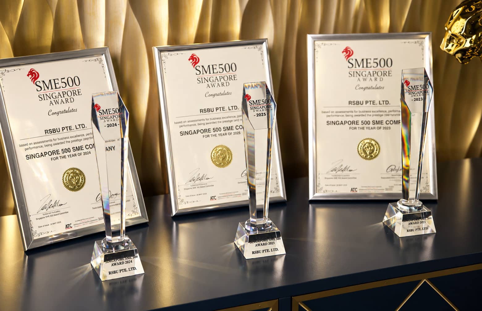 Three Singapore SME 500 Award trophies and certificates for RSBU Pte. Ltd., 2023 to 2025